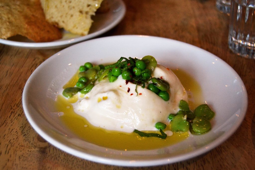 burrata with peas and oil on plate