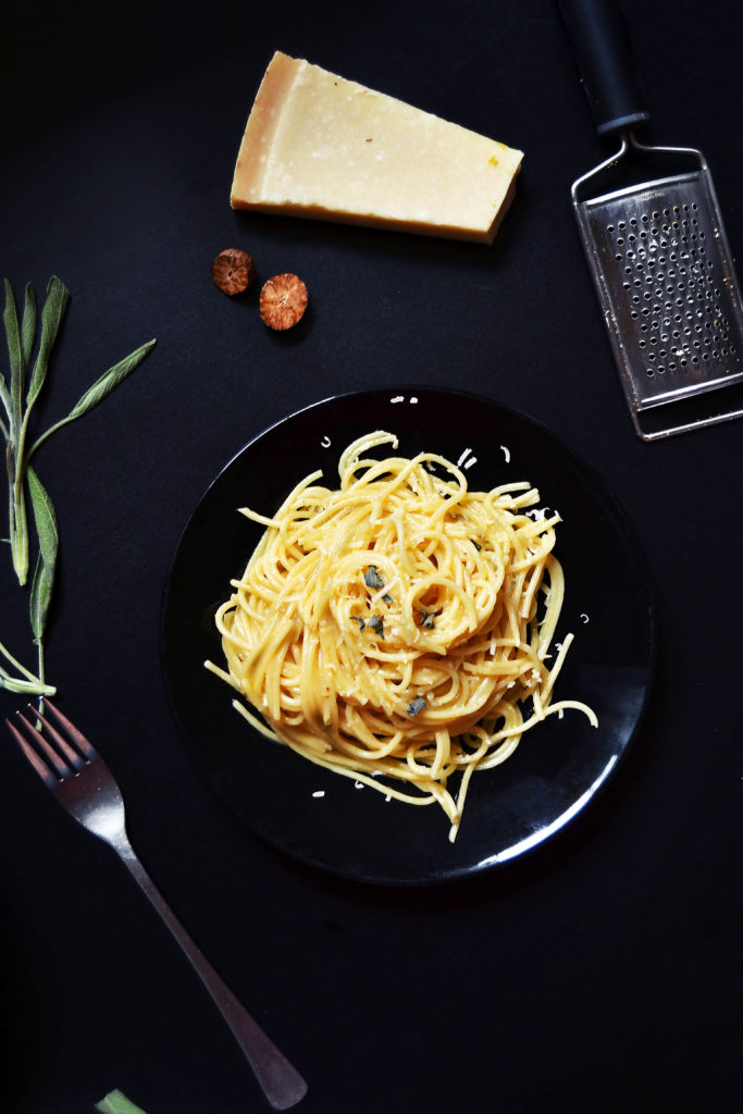 sage butter pasta on table with parmesan cheese